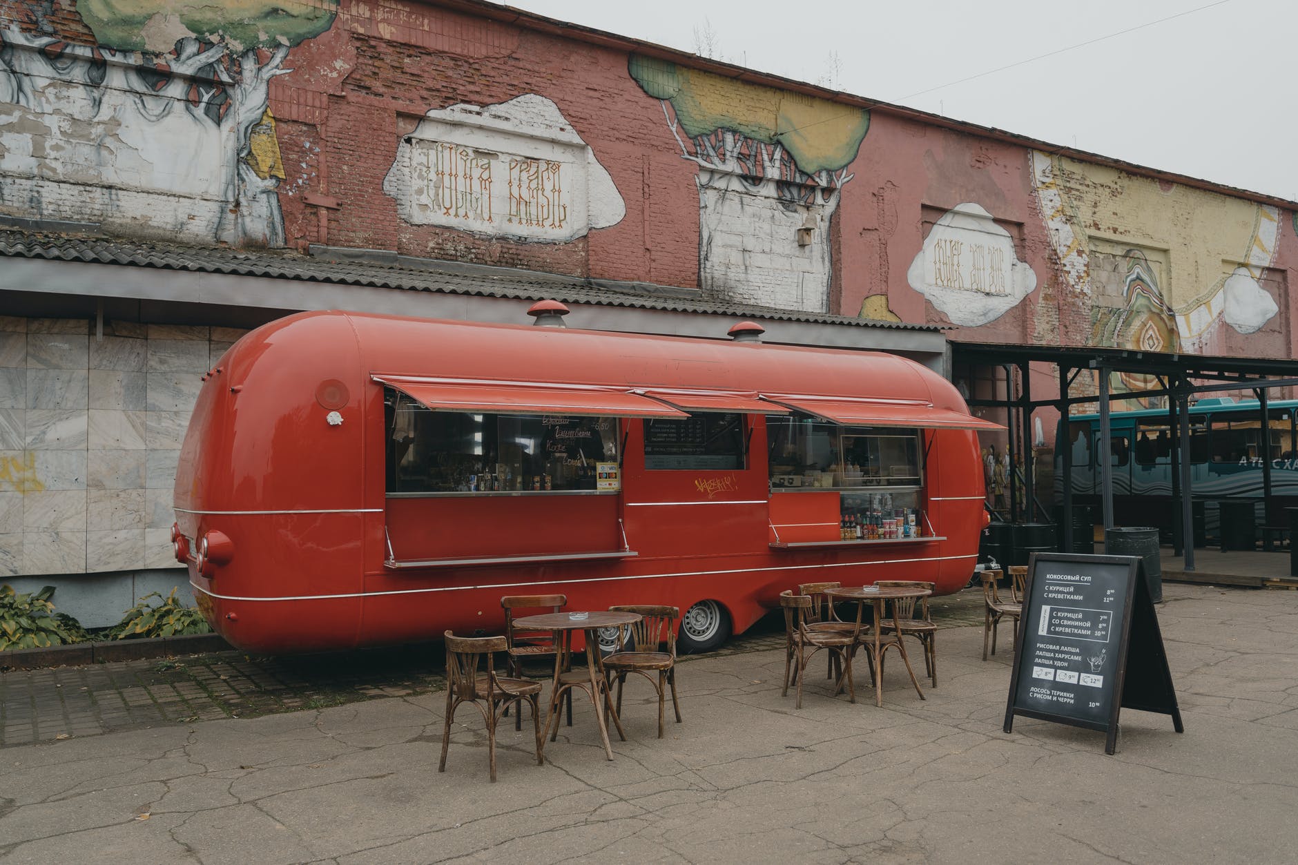 a red food truck on a brick pavement